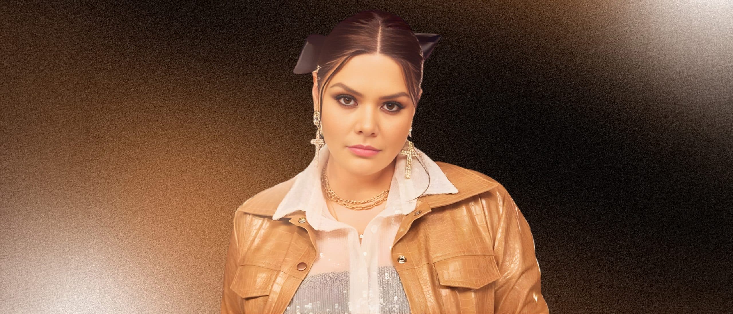 Yuridia retrato promocional con chaqueta dorada y aretes brillantes, cantante mexicana de balada pop lista para eventos y conciertos en vivo