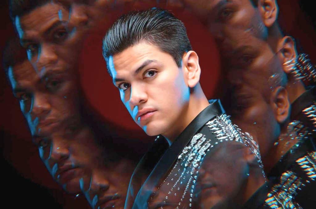 Virlán García en retrato artístico con efecto múltiple, traje negro con detalles brillantes, mirada intensa, ideal para contratación de shows en vivo